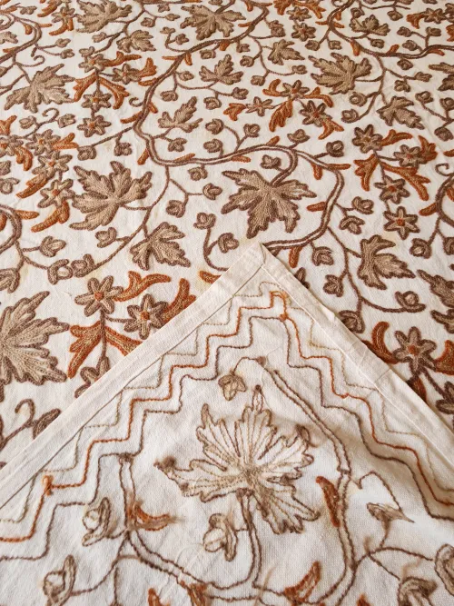 Laine Coton Floral Embroidery bedspread: focus on the handmade embroidery work in India of the floral motif inside and outside presentation folded bedspread