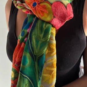 Femme portant une étole en cachemire brodée aux motifs floraux multicolores.