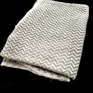 Écharpe en cachemire gris clair avec motif chevrons, tissée à la main. Douce, légère et raffinée, idéale pour un style élégant et intemporel.