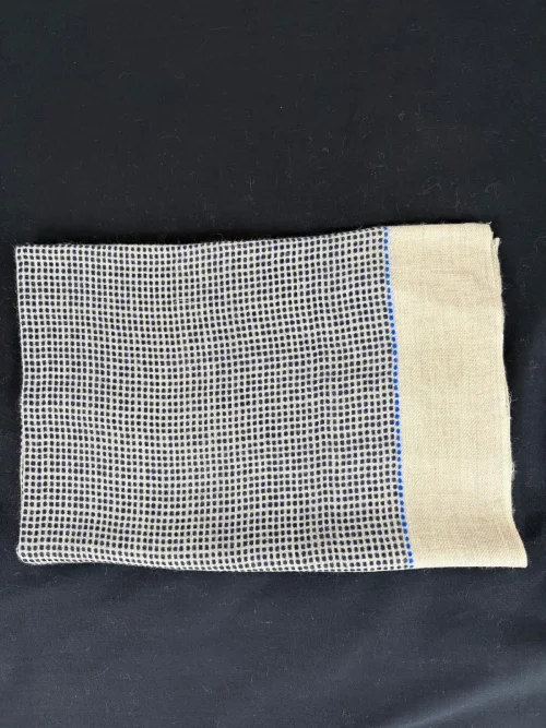 étole cachemire motif quadrillé noire présentée pliée sur fond noir