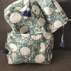 Ensemble de trois trousses toilette coton indiennes bohèmes VANAMALA fermées, présentant un motif floral rétro vert et crème des pompons bleu marine décoratifs.