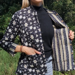 Femme montrant la doublure rayée de la veste coton réversible Chandni, manches retroussées.