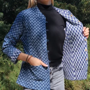 Femme portant la veste khanta Asha ouverte, manches longues retroussées, motifs blancs sur fond bleu marine.